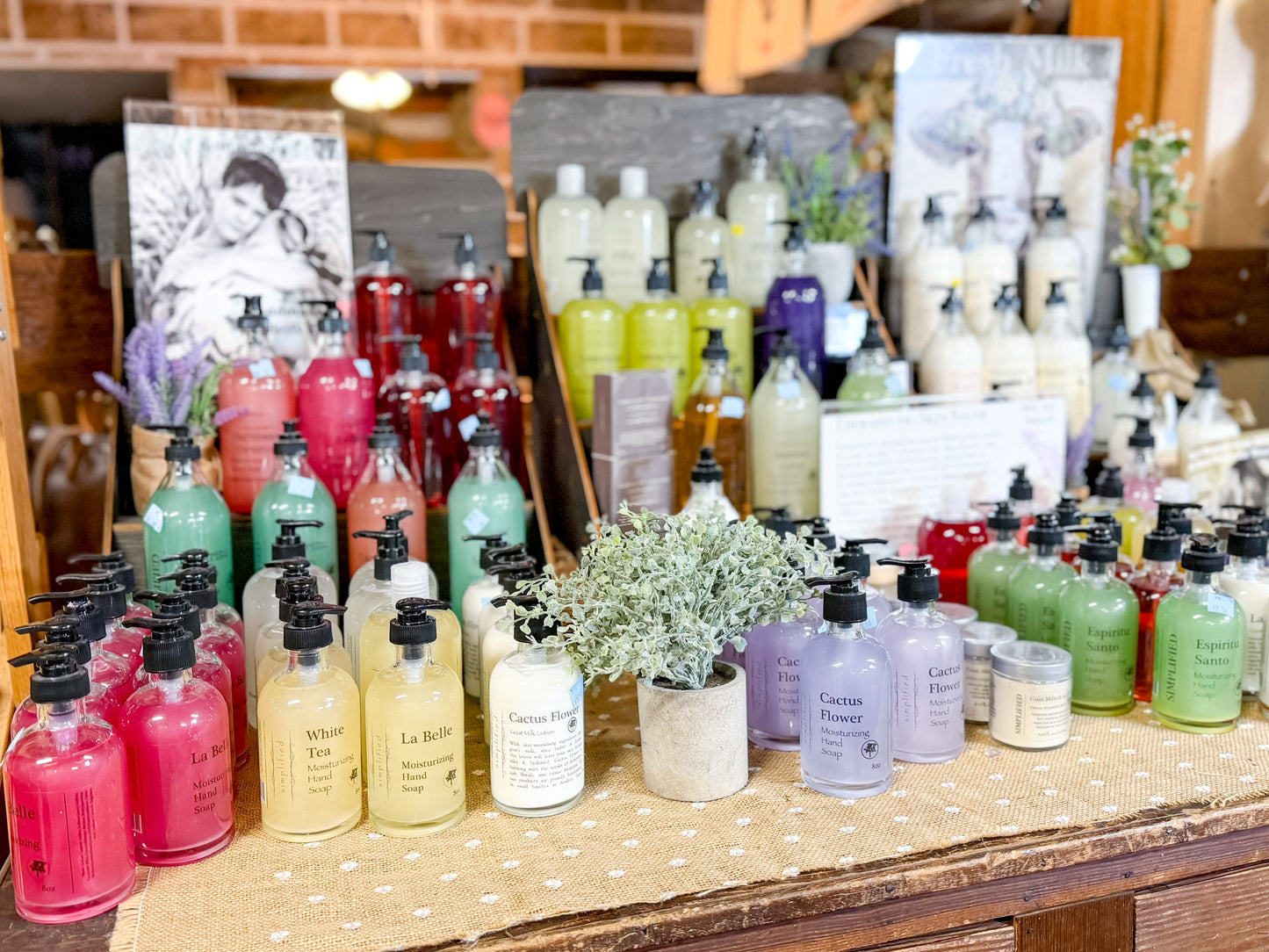 Assorted bottles of hand soap and lotions on a wooden table with a blurred background
