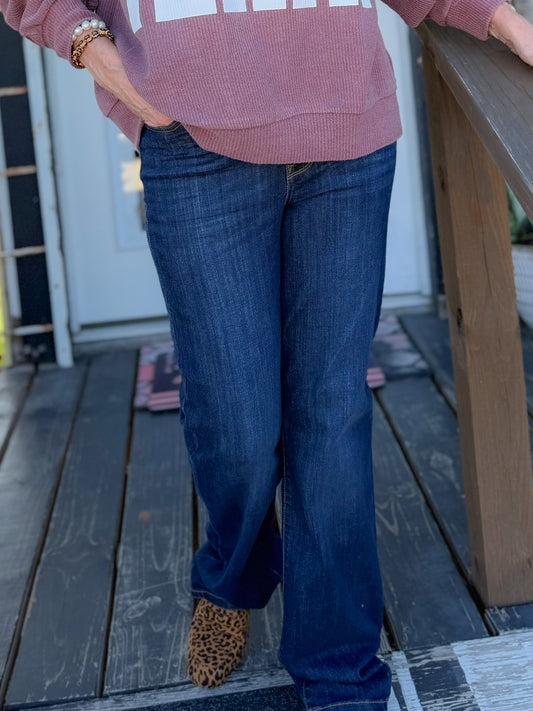 Woman wearing a 'TEXAS' sweatshirt on a wooden porch with Christmas decorations.
