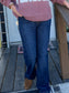 Woman wearing a 'TEXAS' sweatshirt on a wooden porch with Christmas decorations.